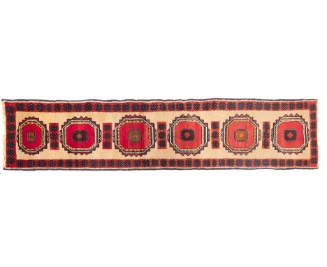 A Turkoman runner, the beige field with six octagonal rose serrated medallions, enclosed by main brick geometric medallion bo