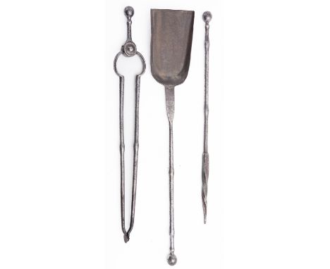 A set of steel fire irons in George III style, 19th century; comprising shovel, poker and tongs; the grips with sphere termin