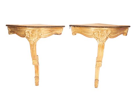 A pair of carved and giltwood bow front corner console tables in Louis XV style, mid 19th Century; the later tops with studde