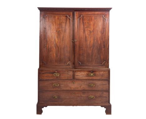 A George III mahogany linen press, circa 1800; with moulded and dentilled cornice above twin panel doors opening to five slid