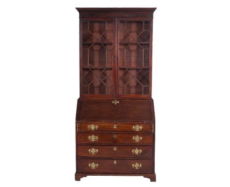 A George III mahogany bureau bookcase, late 18th century; with moulded and dentilled cornice above two glass doors with geome