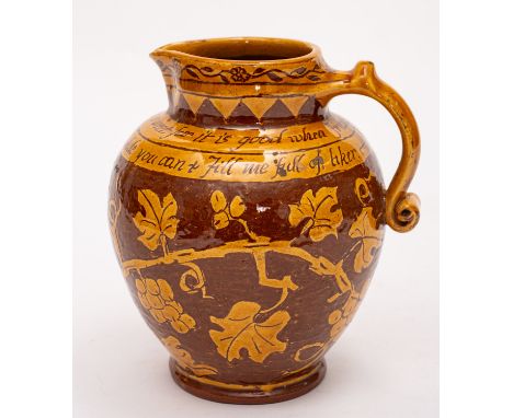 A terracotta jug sgraffito decorated in the North Devon manner with fruiting vine below the caption 'Fill me full of licker t