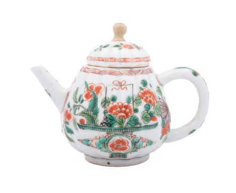 A small Chinese famille verte teapot and cover, Kangxi of ribbed form, painted to each side with a large jardiniere of flower