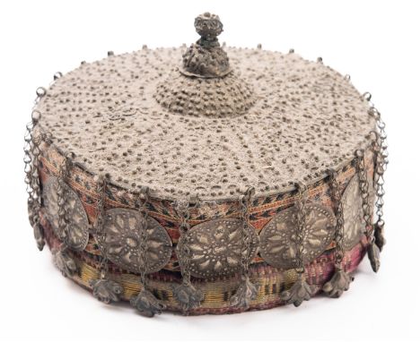 A Central Asian white metal-mounted woven fabric hat, early 20th century set with floral plaques and pendant motifs, 19cm wid