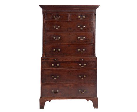 A George III mahogany chest on chest, the upper part with a moulded dentil cornice and blind fret carved frieze and canted an