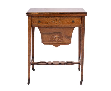An Edwardian rosewood and marquetry games and work table, early 20th Century; the hinged top with central floral motif within