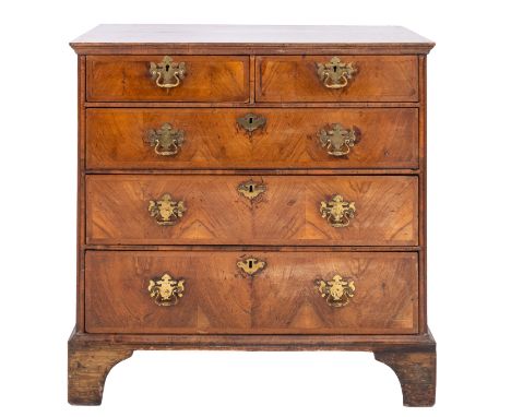 A George II Walnut and crossbanded chest of drawers, second quarter 18th Century; the two short and three graduated long draw