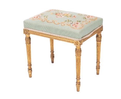 A giltwood and upholstered dressing table stool in Louis XVI style, circa 1900; the Berlin woolwork covered seat with moulded