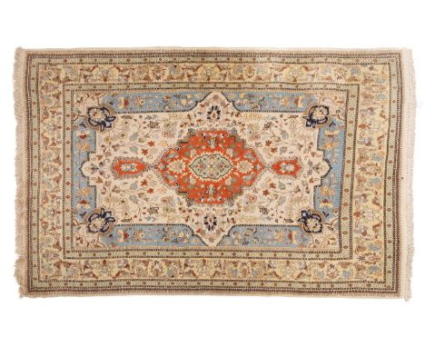 A Kashmir rug, of Persian design, the shaped ivory field with a central rust cartouche pole medallion, all over floral foliat