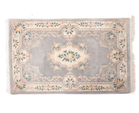 A Chinese superwashed carpet, the pale pastel blue field with a central ivory floral cartouche medallion, enclosed by a simil
