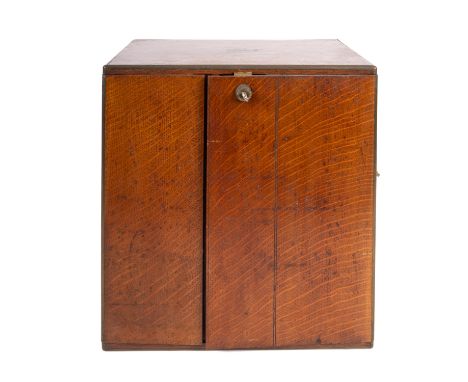A Victorian oak and brass banded cigar cabinet, by the Army &amp; Navy CSL, late 19th century; with a recessed brass swing ha