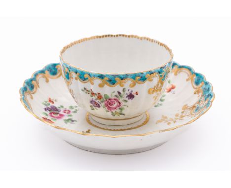 A First Period Worcester teabowl and saucer of fluted form, painted with flower sprays, the lattice patterned turquoise rim w