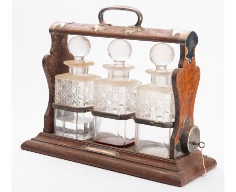 Walker and Hall, 'the Holdfast', an oak and silver plated metal mounted  tantalus, circa 1900; the open frame with a raised l