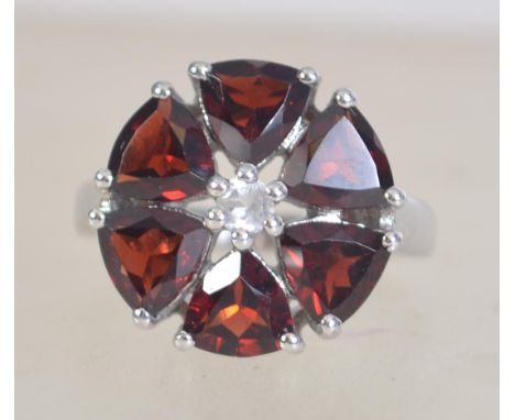 A 925 contemporary silver daisy cluster ring set with garnet glass and CZ. Size L.5. 