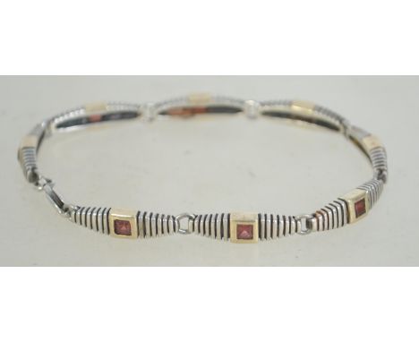A silver 925 bracelet with ribbed cartouche design and inset red stones having a lobster claw clasp. Measures 7cms wide and w