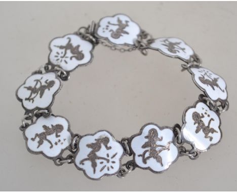 A sterling silver bracelet with white enamel pictorial panels of a deity and safety chain. Weighs 14 grams and measures 6 cms
