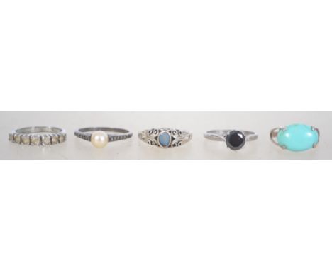 A group of 5 silver 925 dress rings to include one with a pale blue stone, one with a central black stone, one with a central