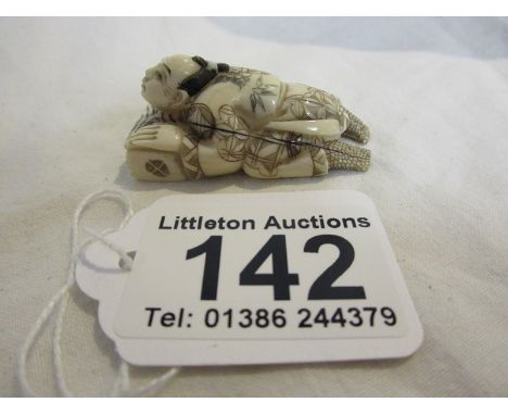 Signed Japanese ivory netsuke - Man lying on pilow