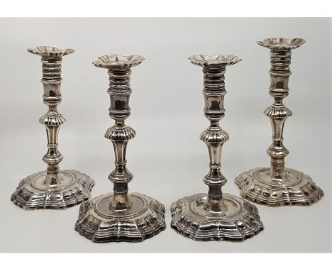 A matched set of four George II cast silver candlesticks, comprising two pairs, both pairs by James Gould, the first pair ass