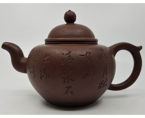 A Chinese Yixing tea pot, with calligraphy to the main body and circular seal to underside.