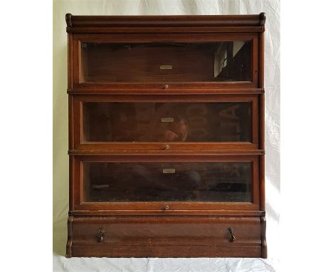 A Globe-Wernicke Co. Ltd. oak bookcase, comprising three glazed book sections, drawer base and top, with applied ivorine trad