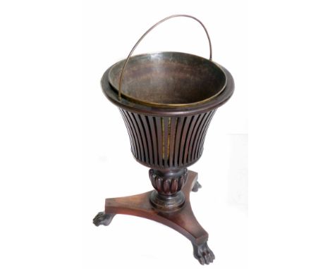 Late 19th century mahogany planter.  Urn shape containing brass liner, turned and reeded column with triform base, animal paw
