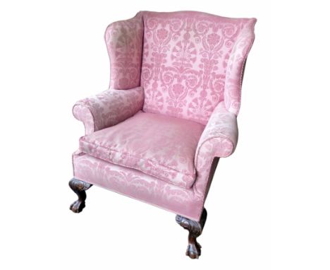 Edwardian wing backed armchair of Georgian design, swab cushion, scroll arms, carved mahogany cabriole legs with ball and cla