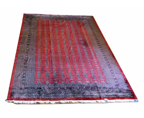 20th century Turkoman carpet madder field, nine rows of elephant foot motifs with gulls, multibanded border. 4.65 x 3.72meter