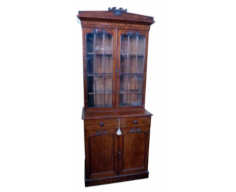 Victorian mahogany bookcase on cupboard, architectural pediment above two astragal glazed doors covering three adjustable she