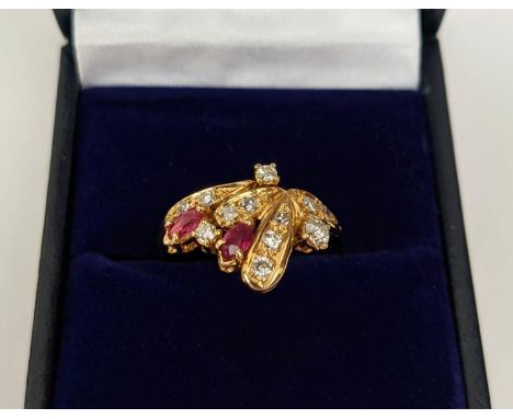 AN 18CT GOLD RUBY AND DIAMOND DRESS RING, set with two marquise cut rubies and a spray of diamonds, ring size P½, 2.98 grams,