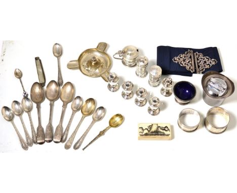 A selection of silver items consisting of peppers, Garrard & Co table lighter, ashtray, nurses belt buckle, napkin rings, mot