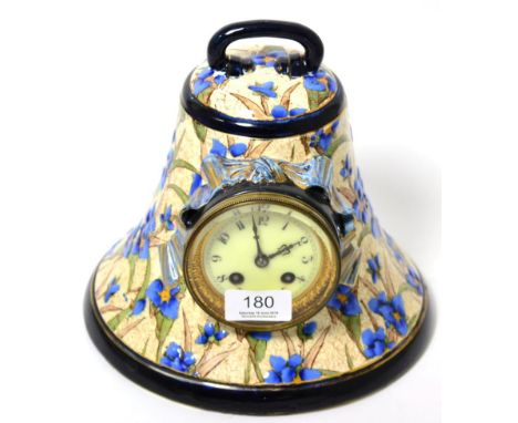 A pottery bell shaped striking mantel clock 