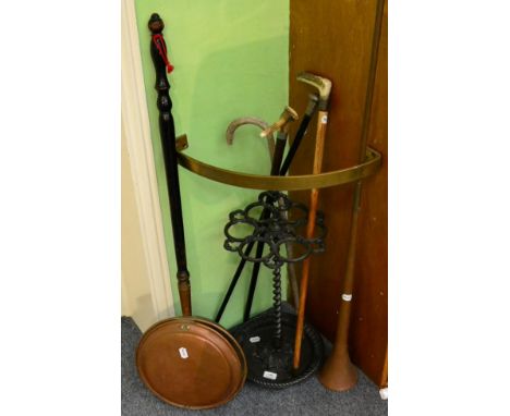 A Victorian cast iron stick stand, a quantity of sticks including one silver mounted example