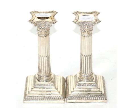 An Edwardian pair of silver Corinthian column candlesticks, by Hutton & Co Ltd London, 1910, stepped weighted bases, 18cm hig