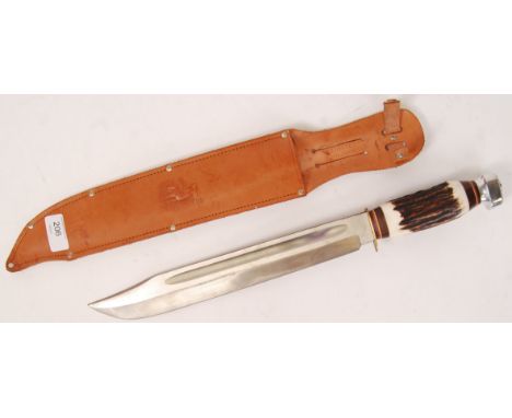 A large contemporary hunting knife, the blade and scabbard marked for Solingen of West Germany. With faux horn handle, and le