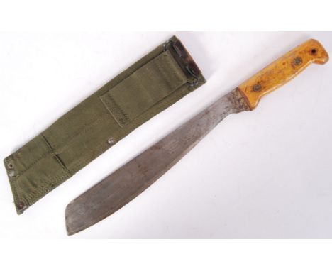 A 20th century military Martindale made Machete, within the original green canvas webbing scabbard. With crocodile mark to bl