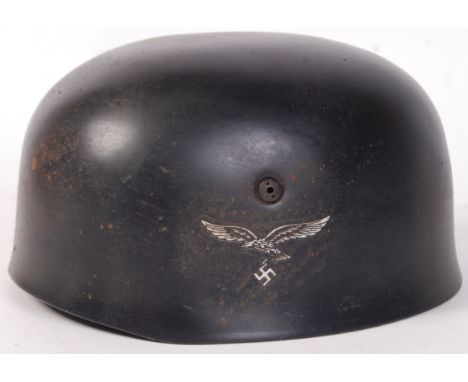 An original WWII Second World War German Paratroopers helmet. With eagle and swastika motif to one side and emblem to other. 