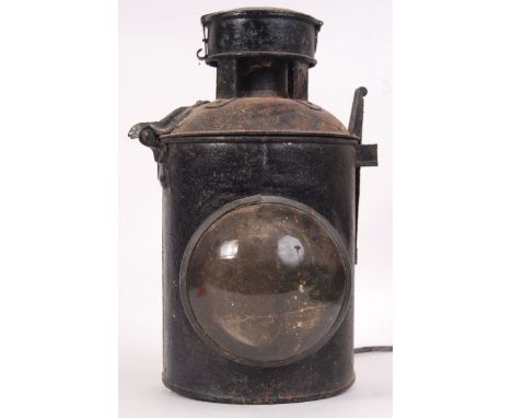 An antique early 20th century electric mountable railway locomotive lamp. With bracket to base, and circular glass lens to fr