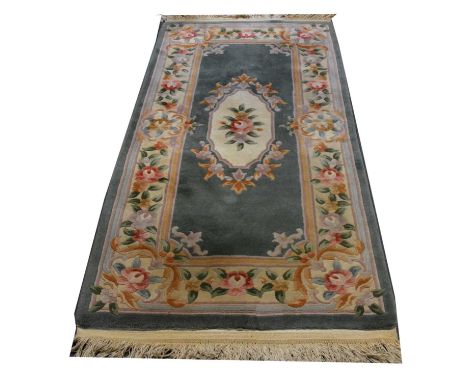 Chinese wool runner, floral medallion and borders on a jade ground, 193x93cm.