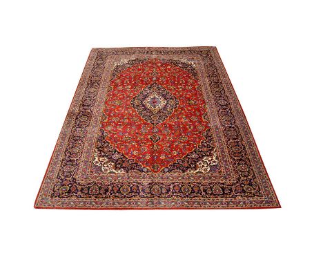 Tabriz carpet, with central medallion in cream and navy against a crimson field with allover flower design, enclosed by multi