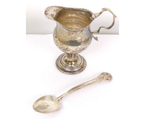 A late 18th century silver cream jug, and an Art Nouveau style spoon, the bowl with hammered decoration (2) 