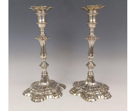 A pair of mid 18th century cast silver candlesticks, on spreading shaped circular bases, with loose sconces, John Cafe, Londo