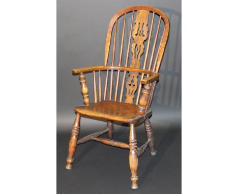 A Victorian Windsor style ash stick back elbow chair, the central carved splat above a plain seat on ringed and turned suppor