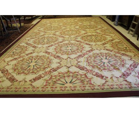 A large Aubusson type carpet, the centre field with stylised floral medallions in taupe, mushroom, pale red and cream, within