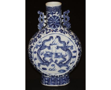 A Chinese porcelain moon flask decorated in underglaze blue to both sides with dragons, and with scrolling foliate pierced ha