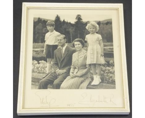 A framed and glazed image of Her Majesty The Queen and Prince Philip with Prince Charles and Princess Anne seated in a garden
