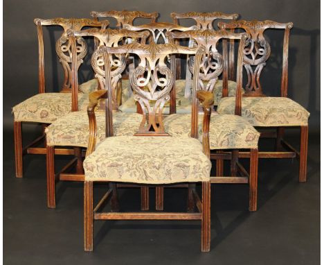 A set of seven George III mahogany dining chairs in the Chippendale manner, the acanthus carved top rails above an ornate ope