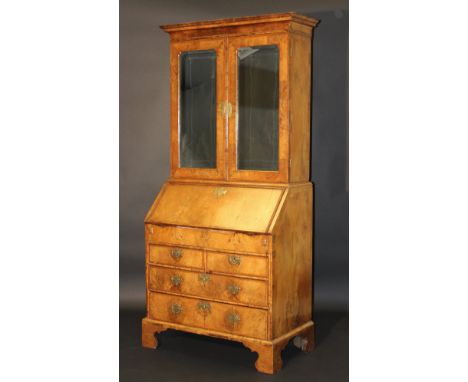 An 18th Century walnut bureau bookcase, the moulded cornice above a pair of Vauxhall glass mirrored doors opening to reveal v