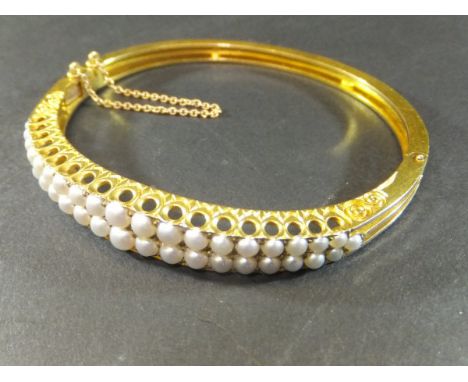 A late 19th Century half pearl hinged bangle of two rows of graduated half pearls set on a pierced shank, approx 5.8 cm diame