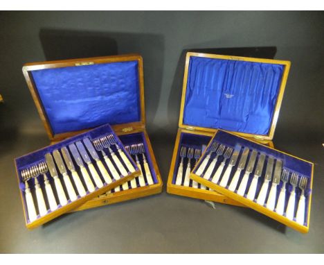 A cased set of twelve mother of pearl handled silver bladed fruit knives and forks (by Francis Higgins & Son Limited, London,